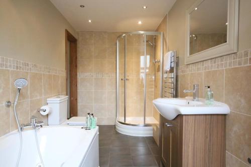 Salisbury Garden Apartment 3 beds 2 baths في Shrewton: حمام مع حوض استحمام ومغسلة ودش