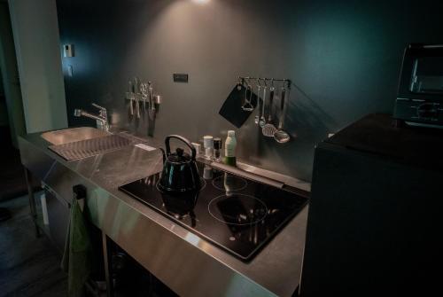 a kitchen counter with a sink and a tea kettle at Nold forest house 那須高原の森の中で心地よく暮らす宿 in Nasu