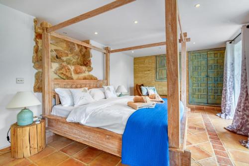 a bedroom with a large bed with a blue blanket at Caroix in Montgo