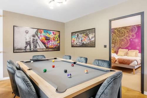 une pièce avec une table de billard avec des chaises et un lit dans l'établissement Les Alizés - Maison 4 chambres - Jacuzzi/Sauna, à Saint-Méloir-des-Ondes