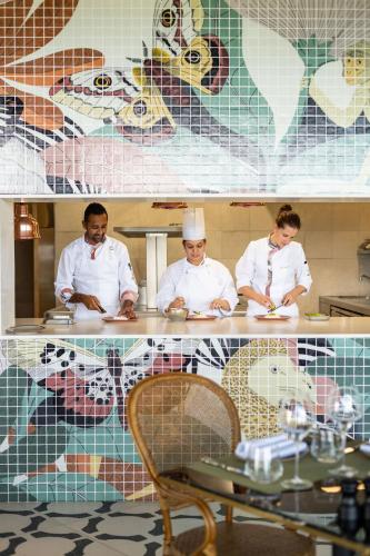 a group of three chefs standing in a kitchen at Legend Hill Resort and Spa in Rivière Noire