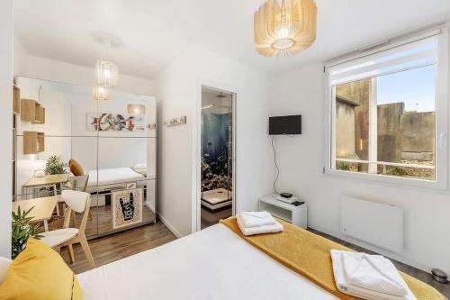 Cette chambre blanche dispose d'un lit et d'une salle à manger. dans l'établissement L'Annexe - Plage 50 m et Remparts à 500 m, à Saint-Malo