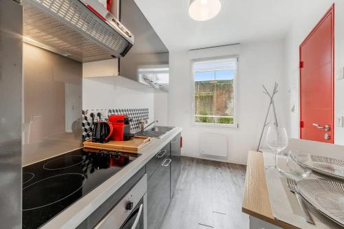 La cuisine est équipée d'un évier et d'une armoire rouge. dans l'établissement L'Annexe - Plage 50 m et Remparts à 500 m, à Saint-Malo