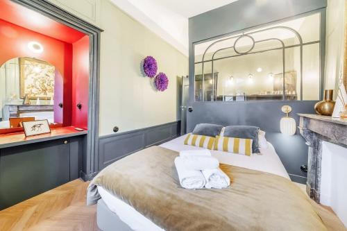 une chambre avec un grand lit avec des serviettes dessus dans l'établissement L’Augustine, appartement atypique, hyper centre, à Rennes