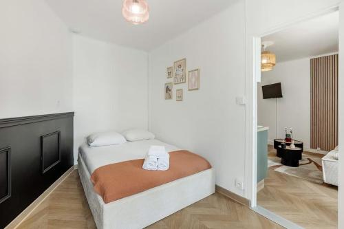 une chambre blanche avec un lit et un miroir dans l'établissement Iliade, bel appartement rénové, centre historique, à Vannes