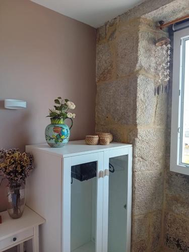 a white cabinet with a vase on top of it at Maravillosa casa con vistas al mar in Baiona