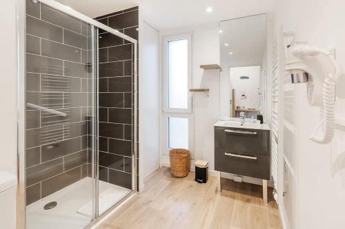 une salle de bain avec une douche en verre et un lavabo dans l'établissement Le Levant - Appartement neuf - 1 chambre - Terrasse, à Cancale
