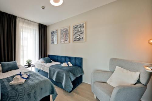 a hotel room with a bed and a chair at Apartamenty Wydma & Las BlueApart in Jastarnia