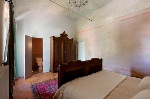 a bedroom with a bed and a cabinet in it at The House in Strevi