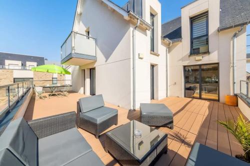 un patio avec une table et des chaises sur un balcon dans l'établissement La Marinière - Terrasse et parking, proche plage, à Saint-Malo