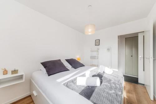 - une chambre blanche avec un grand lit blanc et une table dans l'établissement Le Frida - T2 rénové - Balcon- 500m centre, à Dinard