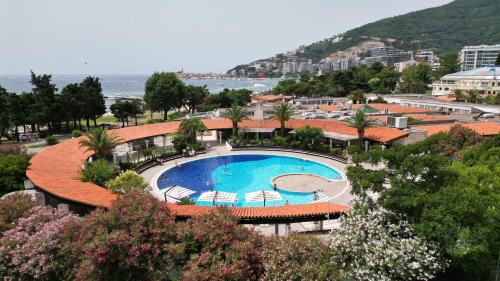a view of a swimming pool with chairs and the ocean at Hotel Slovenska Plaza in Budva