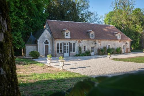 a large white house with a roof at Les charpentes des communs du Château du Sollier - Charme Calme Confort Climatisation à 5mn du péage in Bourges