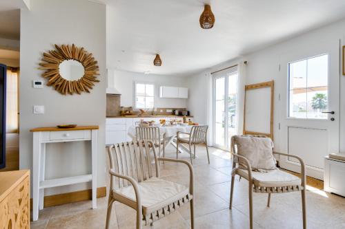 une cuisine et une salle à manger avec une table et des chaises dans l'établissement 700 m de la plage - jardin - maison pour 6, à Barbâtre