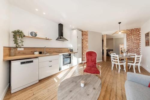 une cuisine et une salle à manger avec une chaise rouge et une table dans l'établissement Le Solidor - Vue mer - Joli pied à terre rénové, à Saint-Malo