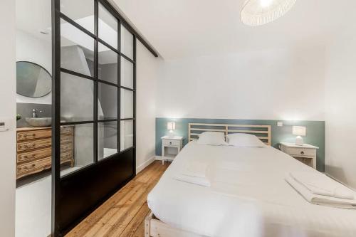 une chambre avec un grand lit blanc et un miroir dans l'établissement Le Solidor - Vue mer - Joli pied à terre rénové, à Saint-Malo