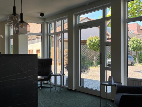 an office with sliding glass doors with a view of a yard at Hotel am Stadthaus in Neuenburg am Rhein