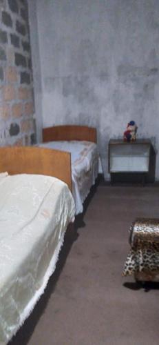 a bedroom with two beds and a dresser and a table at Vacation Home in Ashtarak in Ashtarak