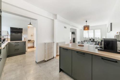 une grande cuisine avec un comptoir et des appareils électroménagers dans l'établissement La Maison Mariotte, 3 chambres, parking extérieur, à Rennes