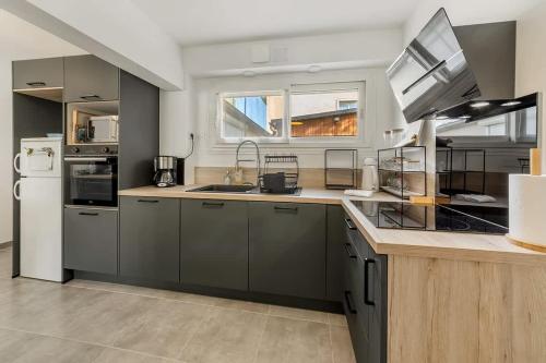 une cuisine avec des armoires grises et un réfrigérateur blanc dans l'établissement La Maison Mariotte, 3 chambres, parking extérieur, à Rennes