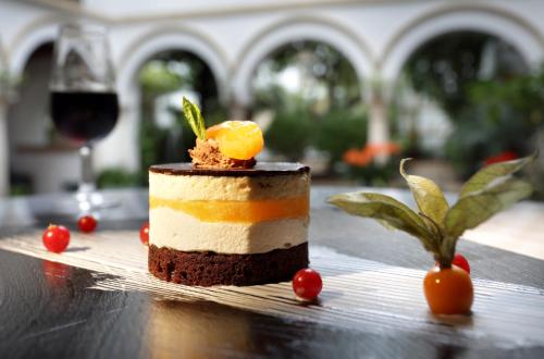 a piece of cake on a table with a glass of wine at Eurostars Conquistador in Córdoba