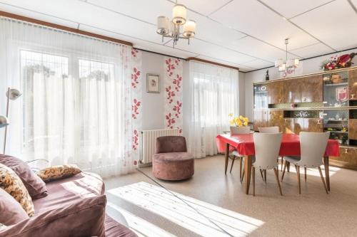 ein Wohnzimmer mit einem roten Tisch und Stühlen in der Unterkunft Maison chaleureuse à Champagney avec vue sur la montagne in Champagney