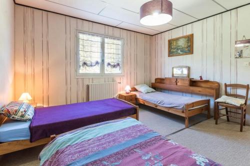 ein Schlafzimmer mit zwei Betten und einem Stuhl in der Unterkunft Maison chaleureuse à Champagney avec vue sur la montagne in Champagney