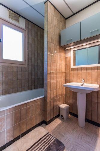 une salle de bain avec un lavabo et une baignoire dans l'établissement Maison chaleureuse à Champagney avec vue sur la montagne, à Champagney