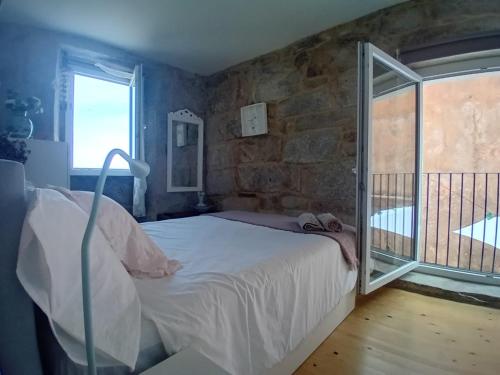 a bedroom with a bed and a stone wall at Maravillosa casa con vistas al mar in Baiona
