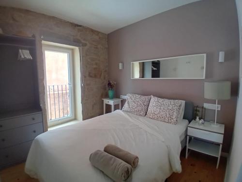 a bedroom with a large white bed and a window at Maravillosa casa con vistas al mar in Baiona