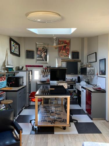 - une cuisine avec un sol en damier noir et blanc dans l'établissement Maison Ulysse, à La Celle-sous-Gouzon