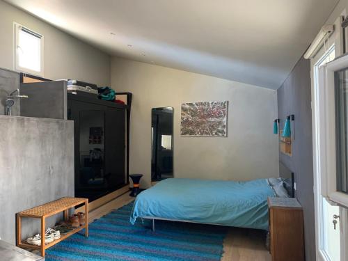 - une chambre avec un lit et un tapis bleu dans l'établissement Maison Ulysse, à La Celle-sous-Gouzon