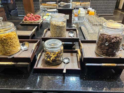 a bunch of jars of food on a counter with spoons at Smile Lanna Hotel in Chiang Mai
