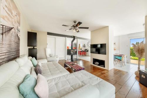- un salon avec un canapé blanc et un ventilateur de plafond dans l'établissement L'Escapade, grande maison, piscine et jardin, à Saint-Père