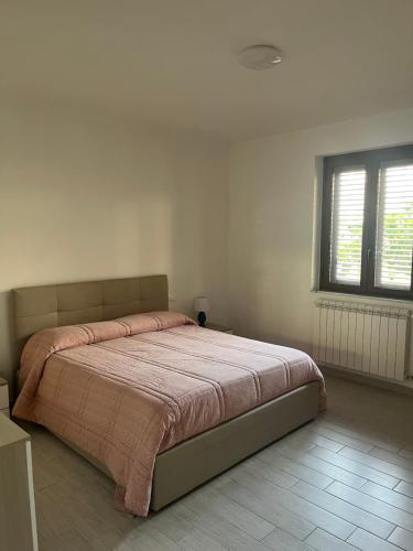 a bedroom with a large bed with a pink blanket at Dimora la Tonnara in Porto San Giorgio