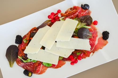 a plate of food with cheese and fruit at Hotel Las Vegas in Lido di Jesolo