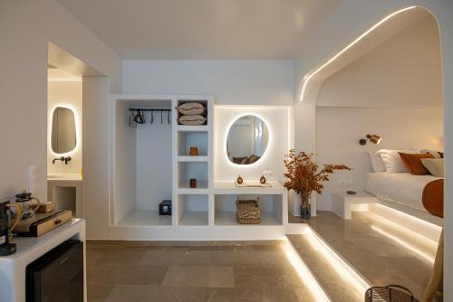 a bedroom with a bed and two mirrors at SEAMENTO suites in Tinos