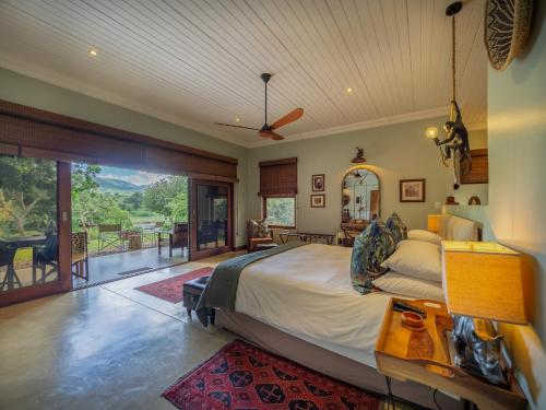 a bedroom with a large bed and a balcony at Kambaku River Lodge in Malelane