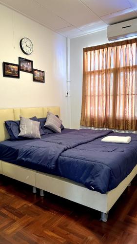 a bedroom with a blue bed with a clock on the wall at ESSENCE Home in Bangkok