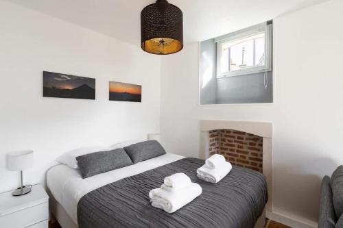 une chambre avec un lit avec des serviettes blanches dessus dans l'établissement Le Descartes emplacement idéal - Gare centre, à Rennes