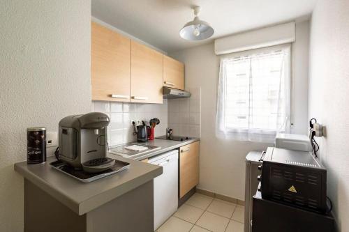 une cuisine avec une cafetière sur un comptoir dans l'établissement Le Sévigné - Cosy et calme - balcon et parking, à Cesson-Sévigné