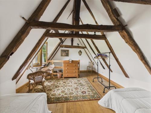 a attic bedroom with a bed and a desk at Piscine et domaine arboré partagés - maison pour 4 in Montignac