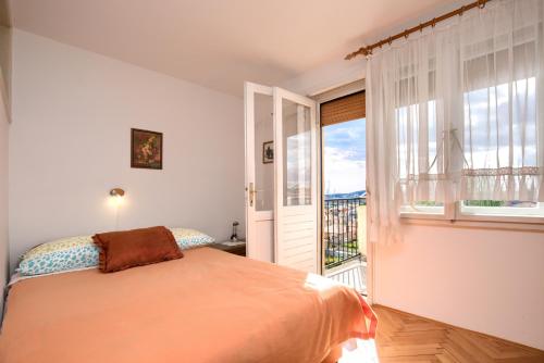 a bedroom with a bed and a large window at Apartman Gordana in Pula