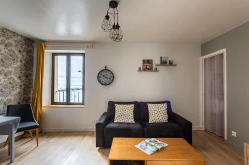 un salon avec un canapé et une table dans l'établissement La Brise- Joli T2 rénové - Vue Mer - 1 chambre, à Cancale