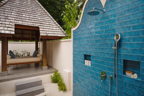 a blue building with a shower and a blue wall at Conrad Maldives Rangali Island in Mandhoo