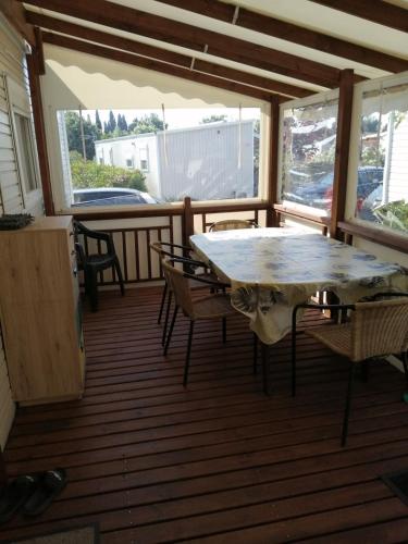 un patio avec une table et des chaises sur une terrasse dans l'établissement Mobil home tout équipé 6 places au calme Fréjus, à Fréjus