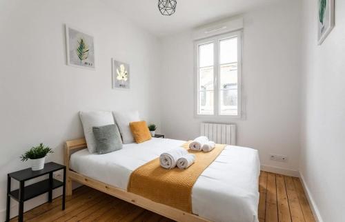 une chambre avec un lit avec deux serviettes dessus dans l'établissement Le Gardelle - Jolie maison de ville (2 chambres), à Saint-Malo