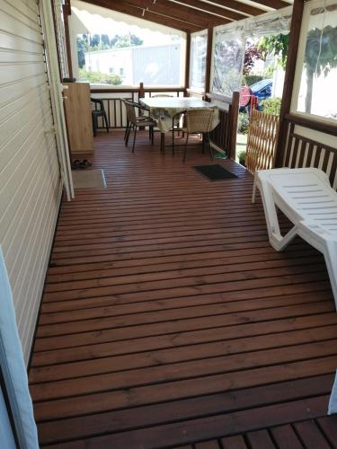 une terrasse couverte avec une table et des chaises. dans l'établissement Mobil home tout équipé 6 places au calme Fréjus, à Fréjus