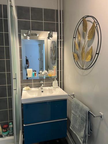 une salle de bain avec un lavabo bleu et un miroir dans l'établissement Charmant Studio près des Champs Elysées, à Paris