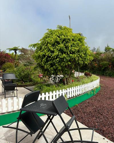 a table and chairs next to a white fence at L'ECHELLE in La Plaine des Palmistes
